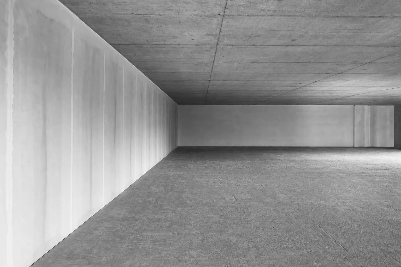 Black and white photograph of a commercial floor plate stripped to base build, bare concrete soffit above and nothing installed on it